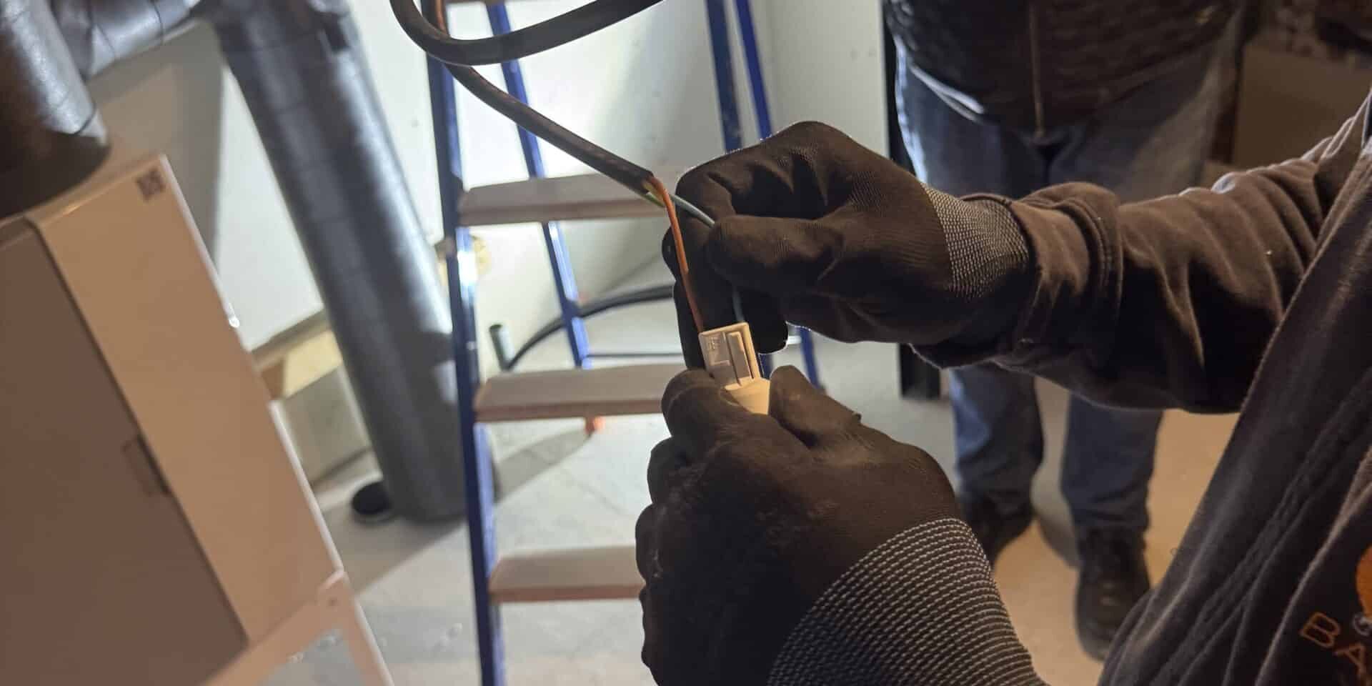 Électricien qualifié en intervention : conseils pour bien choisir son professionnel Électricien qualifié réalisant une installation électrique sur chantier, illustrant les critères essentiels pour choisir un professionnel compétent et certifié.