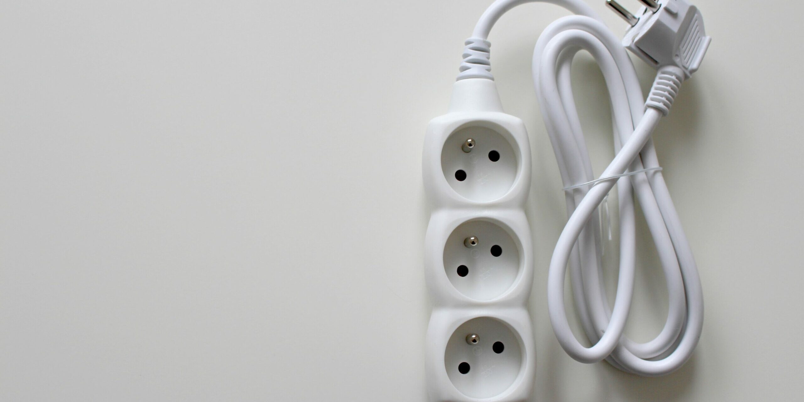 Multiprise électrique blanche équipée de prises avec terre, illustrant le rôle de la prise de terre dans la sécurité des installations domestiques.