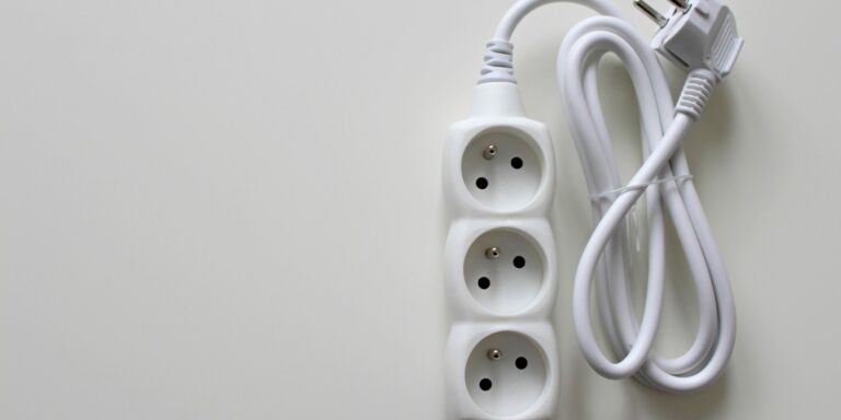 Multiprise électrique avec prise de terre – sécurité domestique Multiprise électrique blanche équipée de prises avec terre, illustrant le rôle de la prise de terre dans la sécurité des installations domestiques.